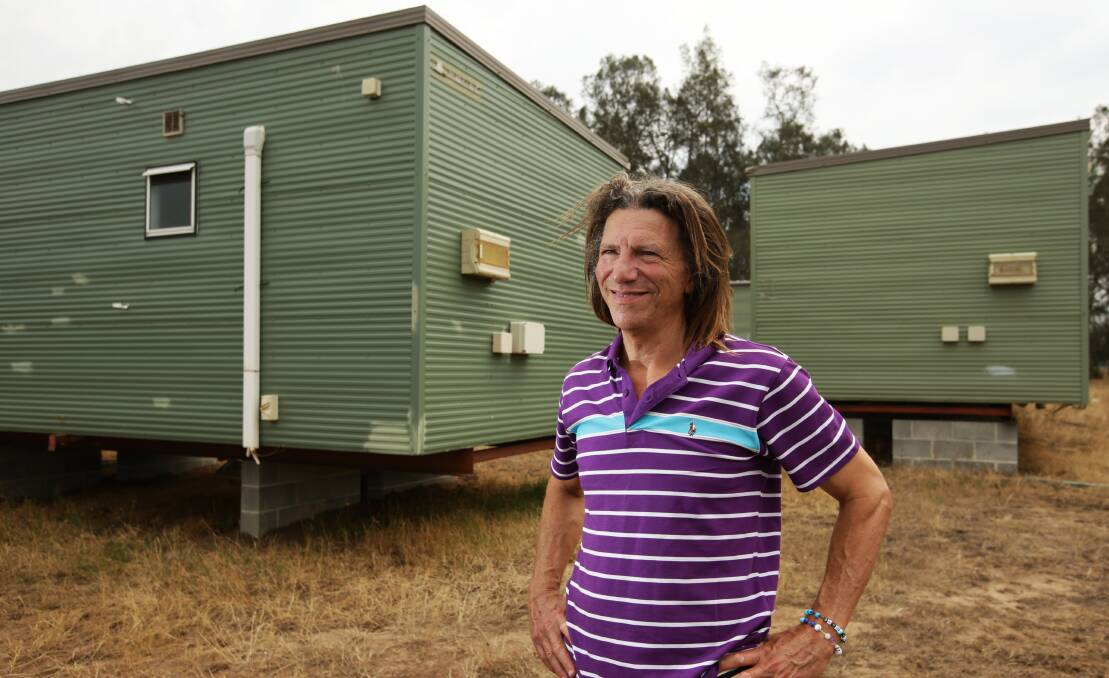 DOING HIS BIT: Jerry Schwartz outside two of the demountable cabins at his Lovedale property. Picture: Simone de Peak
