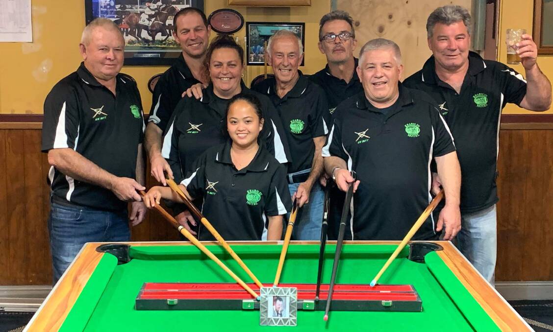 DID IT FOR JIMPEY: Kearsley Kikbutt pool team members Larrie Clarke (captain), Jeff Merchant, Tania Dennis, Ranrose Clarke, Denis MacEnearney, Craig Huchinson,
Chris Parslow and Geoff Tonnet, pointing to a picture of their late assistant coach, Paul 'Jimpey' Janes.