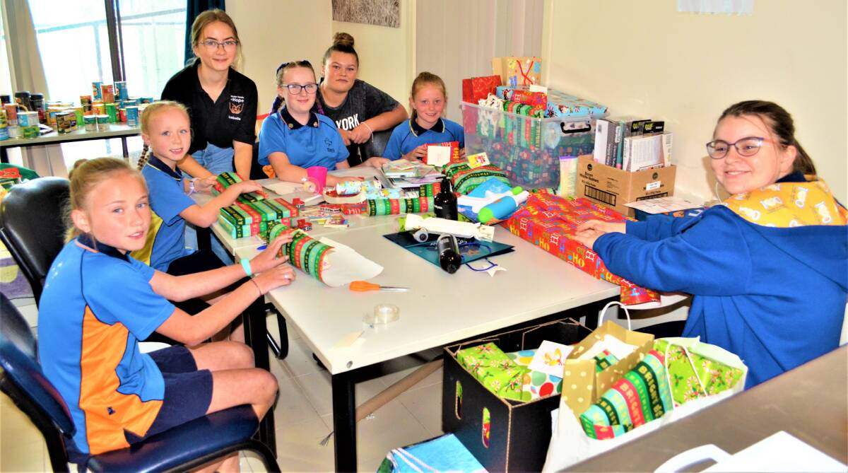 SPREADING KINDNESS: Hunter Hands of Hope and Cessnock Girl Guides volunteers wrapping some of the donated gifts on Monday this week.