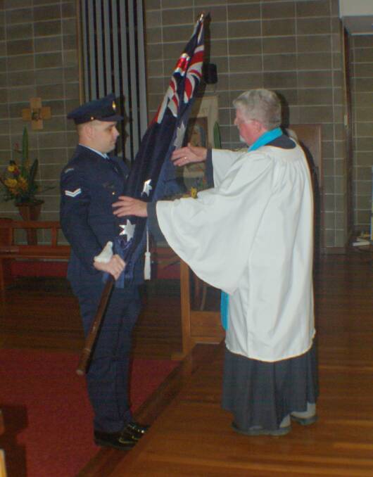 COMMEMORATION: Kurri-born and now Williamtown-based Corporal Struan Dyson-Smith presents the Australian flag to Fr Carl Lanham at the 2017 ANZAC Day commemoration at St Paul's Anglican Church Kurri Kurri.