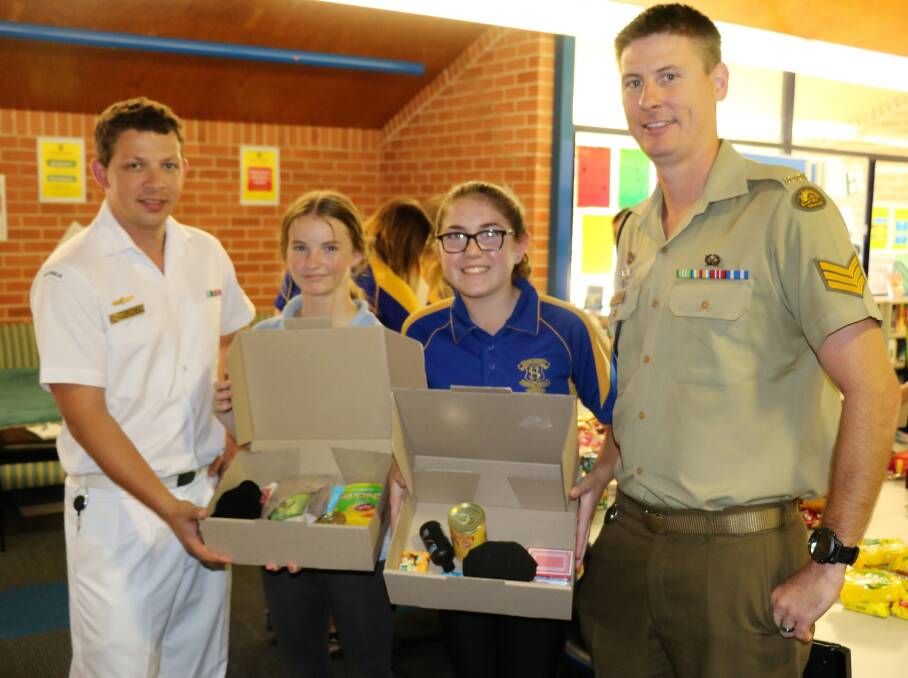 CARING: Leading Seaman Toby Spence, Kurri High students Alyssa Fuller and Elianah Gilbert, and Sergeant Ronald Sim with some of the care package donations.