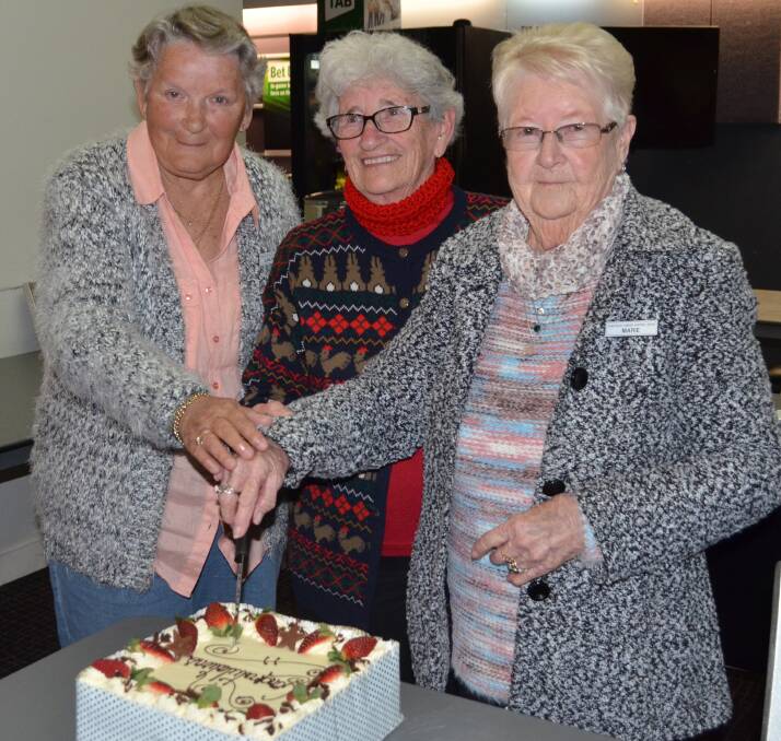 MILESTONE: Coalfields Cancer Support Group secretary/publicity officer Laurel Hopkins, treasurer Mary Kennedy and president Marie Main cut the cake to celebrate reaching $600,000 in fundraising. Picture: Monique Smith