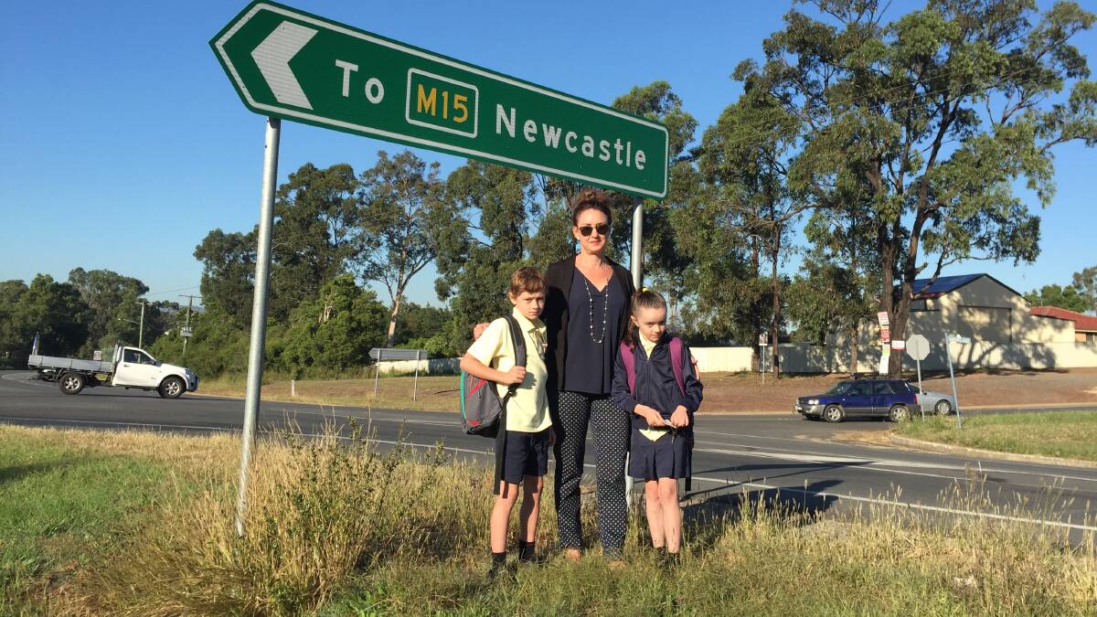 CONCERNS: Weston resident Leanne Martin and her children Billy, 9, and Katie, 8, whom she drives to the bus stop so they don't have to cross Sawyers Gully Road on foot. Picture: Krystal Sellars