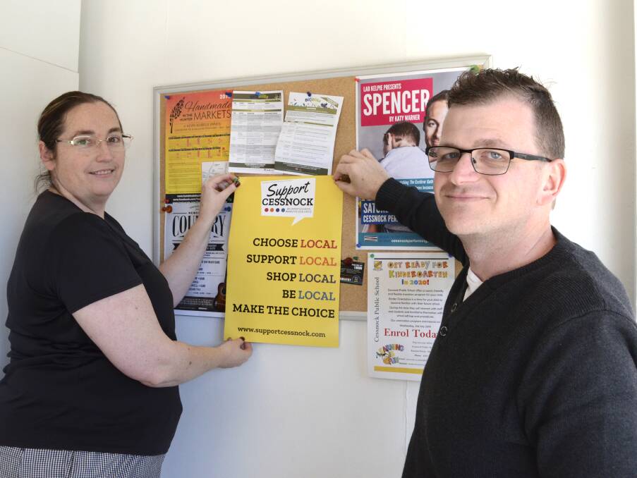 CHOOSE LOCAL: Cessnock Chamber of Commerce vice-president Rienna de Visser and president Clint Ekert with one of the posters that have been distributed to local businesses.