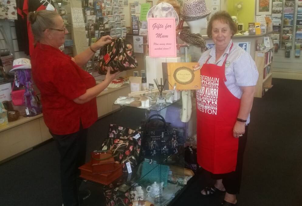 SPECIAL: Towns with Heart volunteer Sharon Dyson-Smith shows a customer some of the gift ideas at the Kurri Kurri Visitor Centre gift gallery.