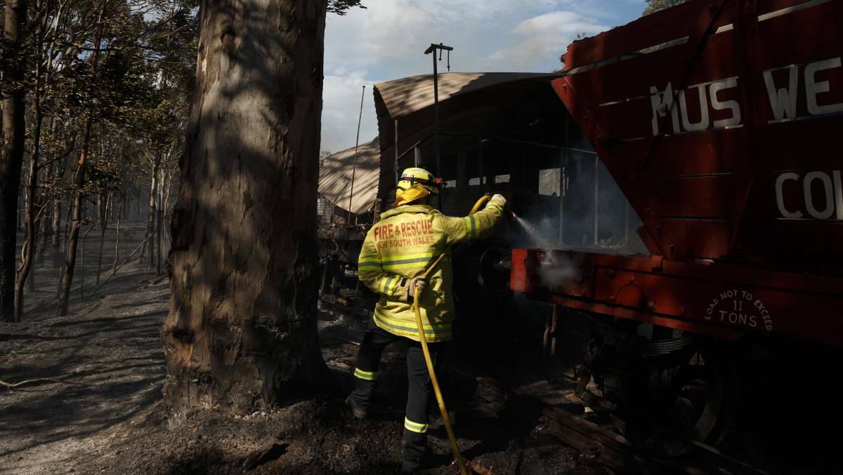 DEVASTATING DAY: A firefighter extinguishes a blaze inside one of the trains at Richmond Vale Railway Museum on September 13, 2017. Picture: Max Mason-Hubers