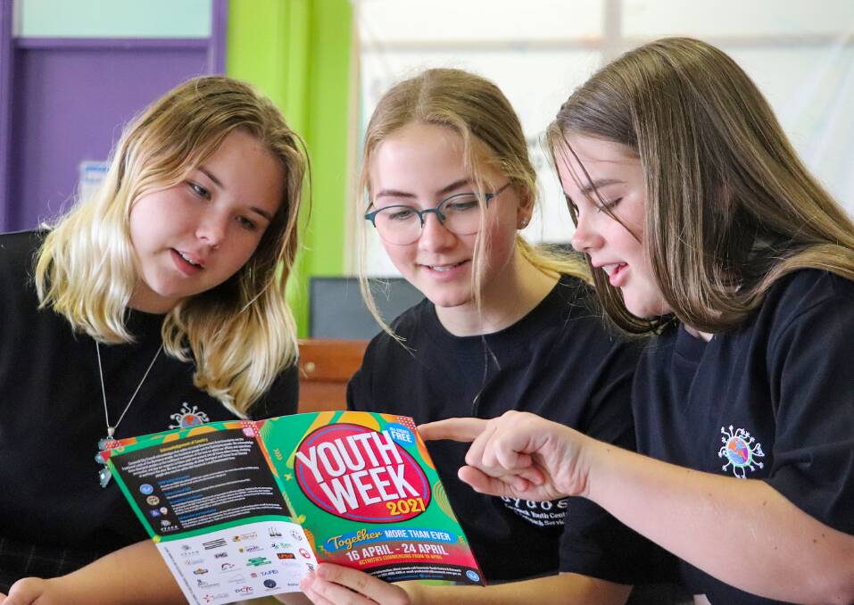 EXCITED: Cessnock Youth Week ambassadors Taylor Grant, Isabella Metcalfe and Abigail Glover look over this year's program.