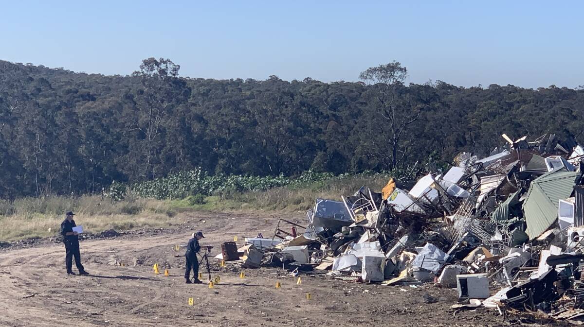 HUNT FOR CLUES: Forensic police survey the scene inside Cessnock Waste Management Centre, where a 54-year-old man suffered fatal injuries on Sunday.
