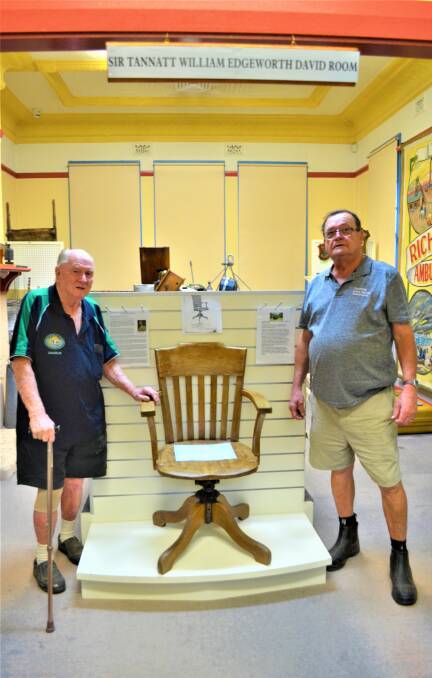 SHOWPIECE: Cessnock Men's Shed volunteer Charlie Charters and Coalfields Local History Association treasurer Peter Allen with the chair restored by Charlie.