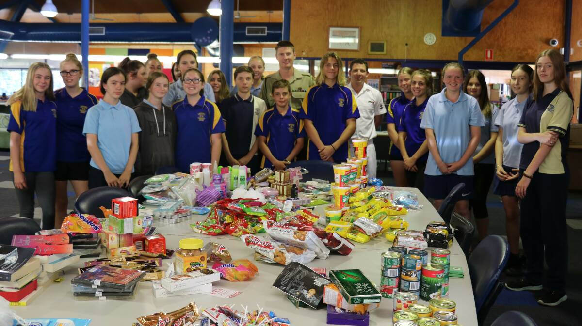GENEROUS: Kurri Kurri High School Year 9 and 10 students and Defence Force guests with the donations ready to be packed and sent off to the troops.