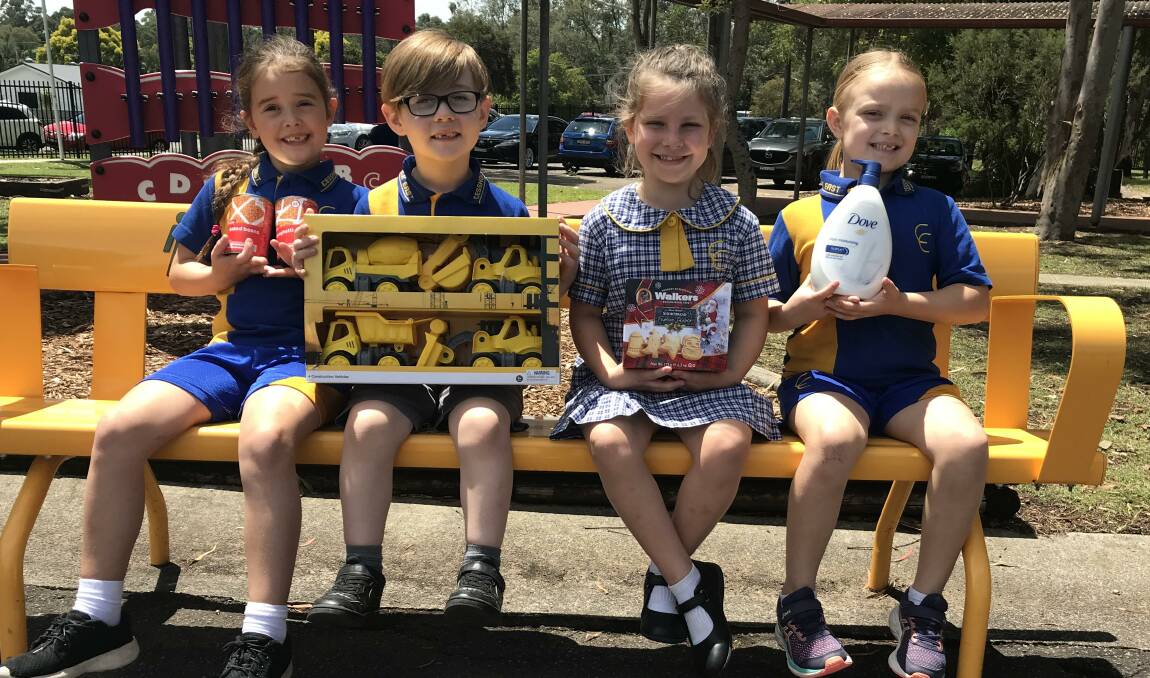 CHRISTMAS CHEER: Cessnock East Public School stage one students Ivy, Finn, Khiara and Jaida with some of the items they are collecting for the Salvation Army.