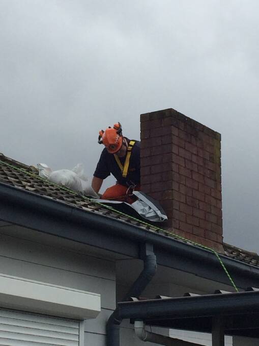 An SES volunteer on a rooftop in the Cessnock area this week. Picture: NSW SES - Cessnock City Unit
