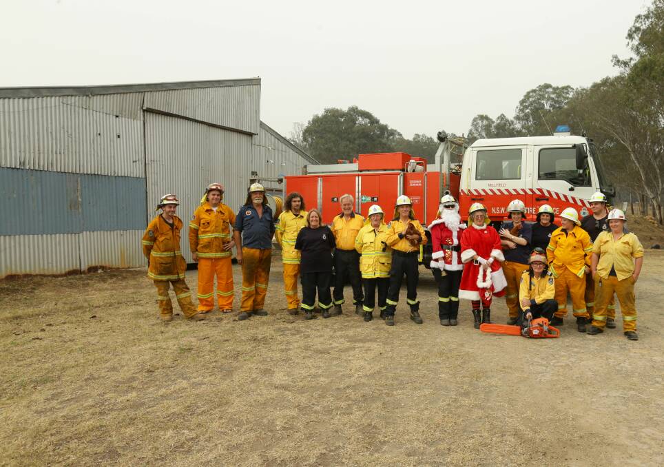 DEDICATED: Millfield Rural Fire Brigade volunteers pictured at their station (a former chicken shed) on the day of their Santa Run in December. Picture: Jonathan Carroll