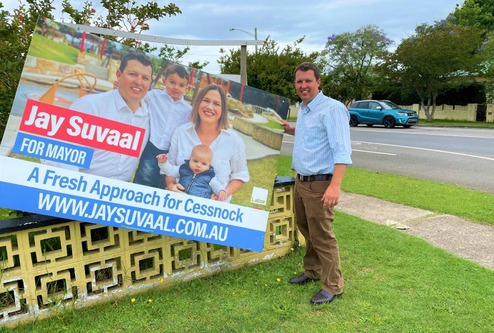 CAMPAIGN OVER: Labor candidate Jay Suvaal, who is leading Cessnock's mayoral race, takes down a campaign poster at West Cessnock on Monday.