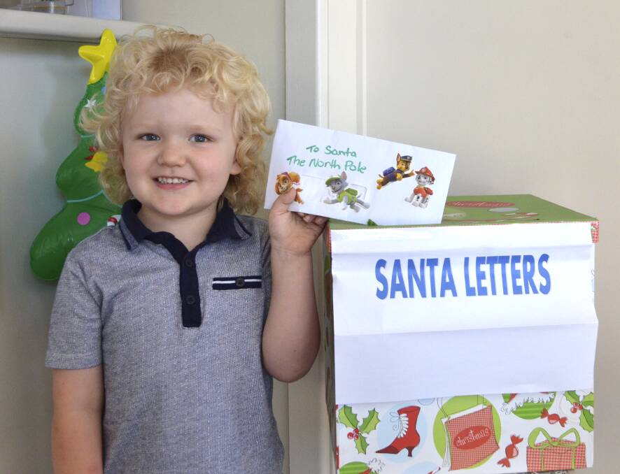 CHRISTMAS WISHES: Alistar Ball, 4, of Cessnock, drops his letter to Santa in the box at the Advertiser office. Picture: Krystal Sellars