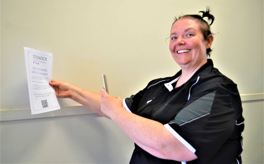 CLICK: Cessnock Chamber of Commerce board member Stacy Jacobs demonstrates the customer service awards' QR code function.