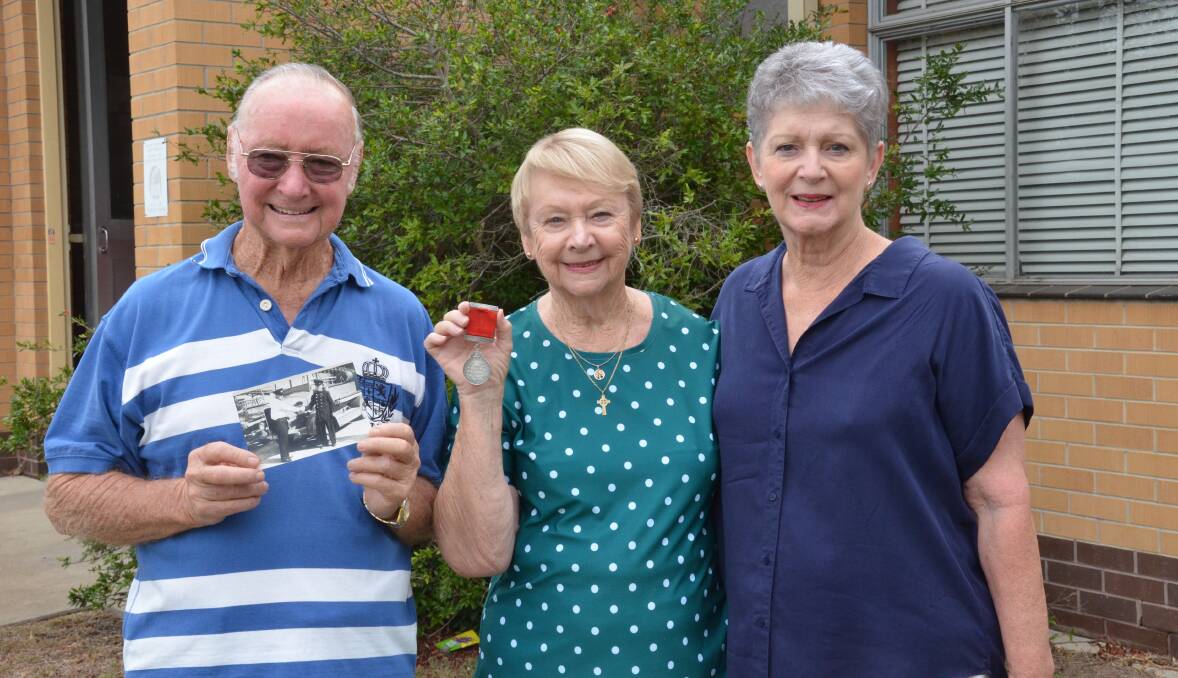 FAMILY TIES: Long-serving Weston Fire Brigade captain Edward John 'Bluey' Frame's children Alex Frame (holding an old photograph of his father) and Dawn Frame O'Connor (holding her father's 30-year service medal) and his granddaughter Julie Frame Falk at Weston Fire Station. Picture: Krystal Sellars