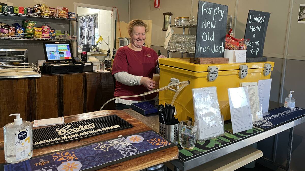 GOOD TO BE BACK: Wollombi Tavern manager Petrina Walsh pours a beer at the temporary bar on Monday. Picture: Krystal Sellars