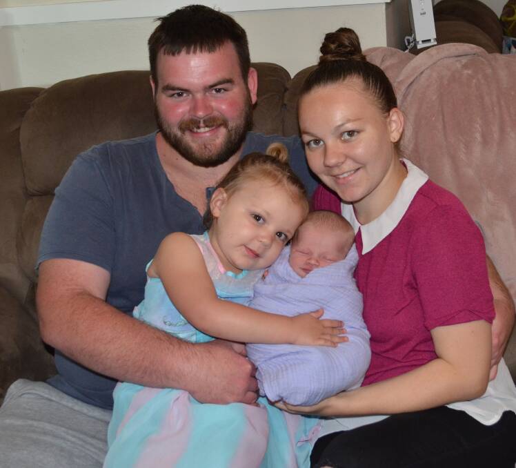COULDN'T WAIT: Violet Thoren, who was born in the car on Lovedale Road, gets a cuddle from sister Maddison Phillips, dad Patrick Thoren and mum Lorraine Travers.