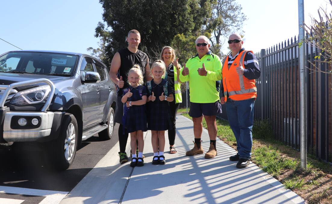 SAFETY: The Crouch family at the new kiss-and-drop zone at Holy Spirit Infants School Abermain, alongside Cessnock City Councils principal engineer Warren Jeffrey and roads crew team member John Rushford. Picture: supplied