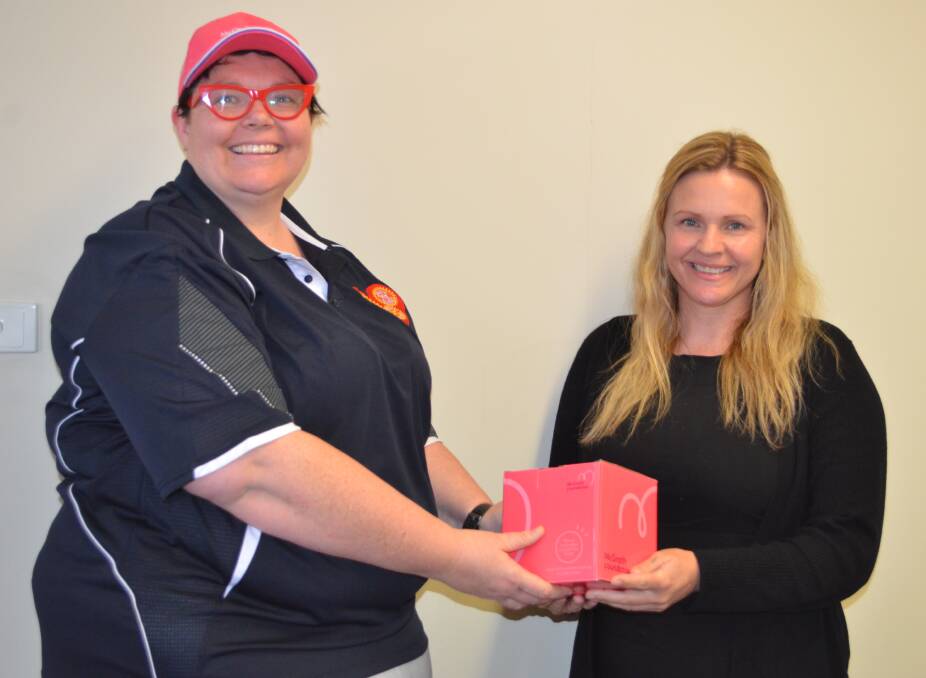 GREAT CAUSE: Pink Up Your Town Cessnock's local champion Stacy Jacobs hands over a McGrath Foundation donation box to Sally Tindall.