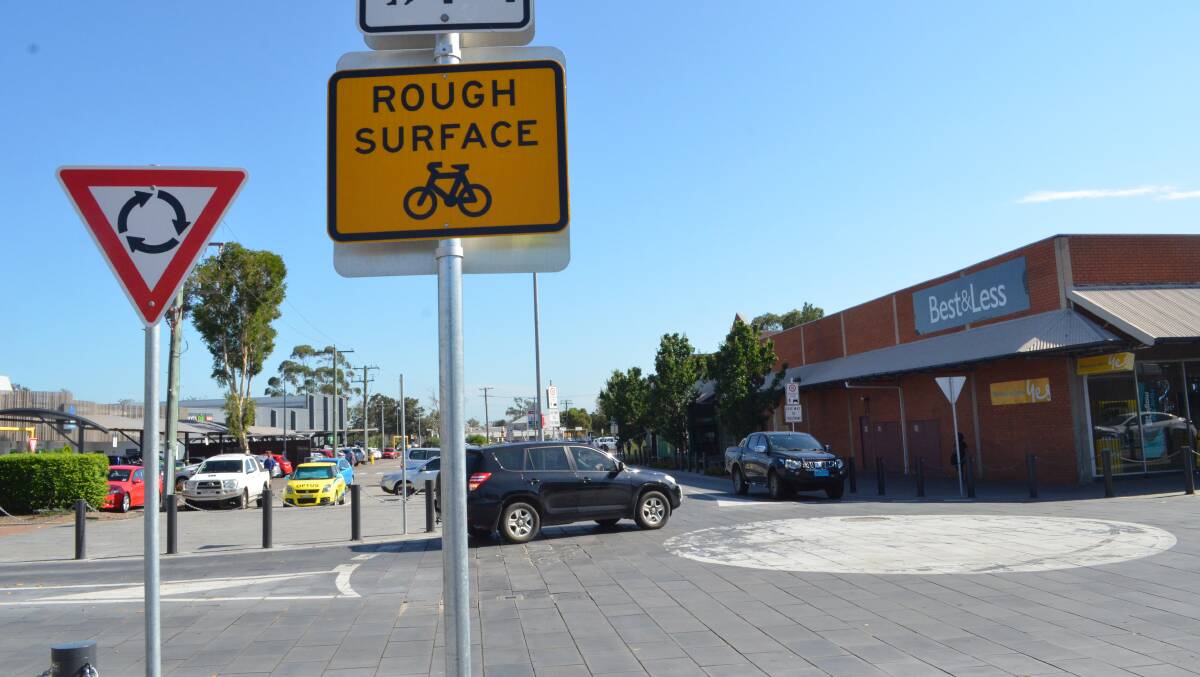 ROUGH SURFACE: Cessnock City Council has installed hazard signs to alert road users to the cracked pavers at the corner of Cooper and Charlton streets, and will undertake repair work in the new year.