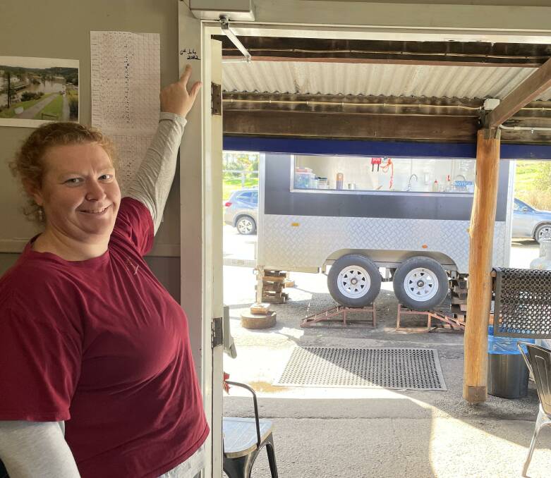 REMINDER: Wollombi Tavern manager Petrina Walsh points to the flood height on the door frame. The food truck in the background is the tavern's temporary kitchen.