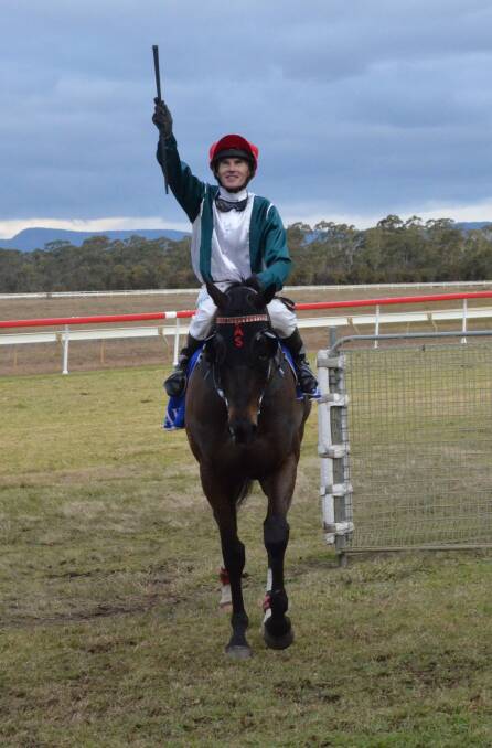 VICTORY: Robert Thompson salutes the crowd after riding Youthful King to victory in the 2015 Jungle Juice Cup at Cessnock. 