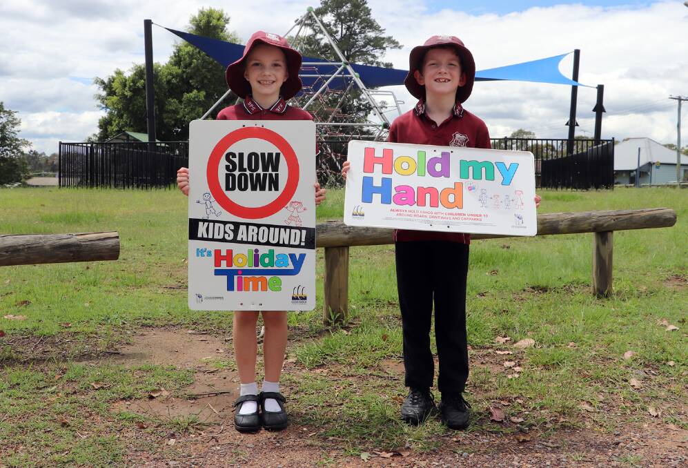 SAFETY: Bellbird Public School students Beau Snaddon and Lincoln Harris with some of the signage for the holiday road safety campaign.