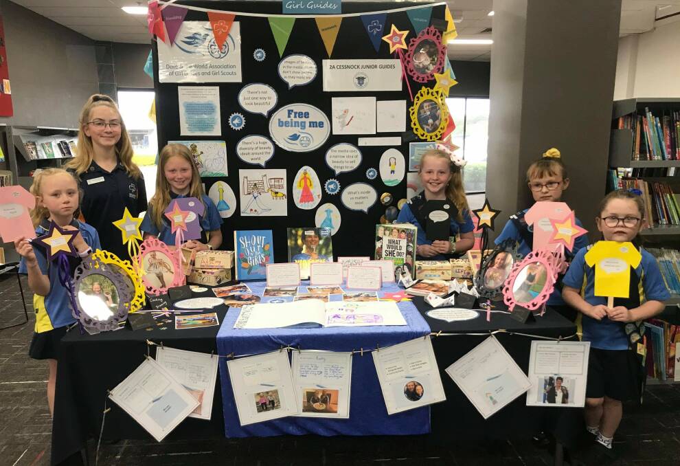 POSITIVE MESSAGES: Junior Guide leader Isabella Metcalfe and some of the Cessnock Junior Guides with their Free Being Me display at Kurri Kurri Library.