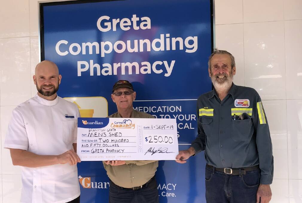 SUPPORT: Greta Guardian Compounding Pharmacy pharmacist Philip Smith presents Branxton-Greta Men's Shed members Dick Wesseling and Kevin Bell with their prize.