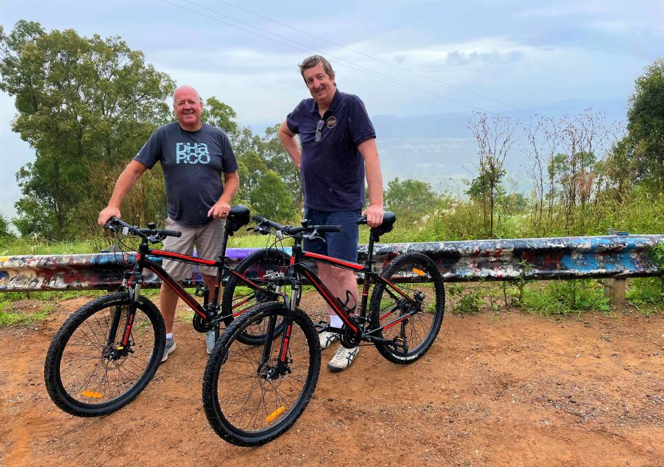 POTENTIAL: Local cyclists Martin Parker and Steve Whitby at Bimbadeen Lookout. The graffiti on the guardrail has been painted over since this picture was taken.