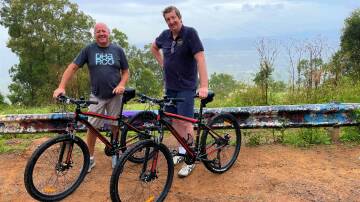 POTENTIAL: Local cyclists Martin Parker and Steve Whitby at Bimbadeen Lookout. The graffiti on the guardrail has been painted over since this picture was taken.