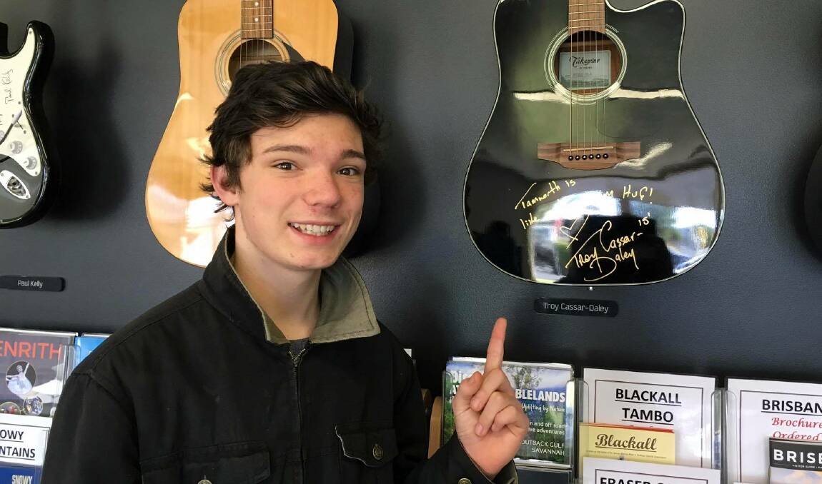 IDOL: Finnian Johnson points to a guitar signed by Troy Cassar-Daley on a recent visit to the Tamworth Visitor Information Centre. Picture: Michelle Page