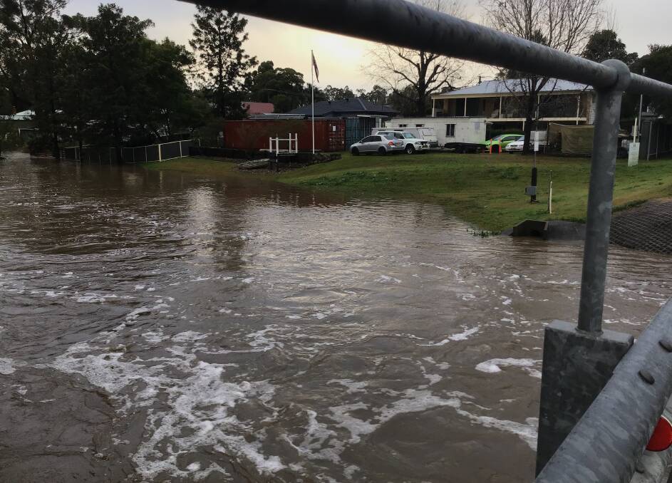 TORRENT: Swamp Creek rises in William Street, Abermain on Tuesday afternoon. Picture: Michelle Beauchamp