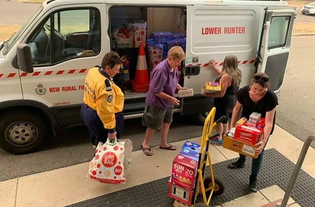 Volunteers load up the van with donations for the firefighters on Friday. Another collection will be held at the Cessnock basketball stadium on Monday.
