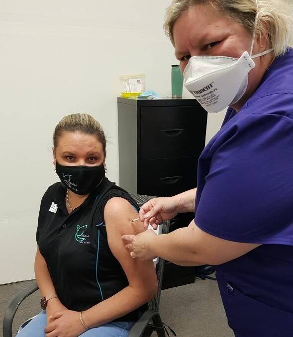 VACCINATED: Believe Services managing director Lisa Wiggins receives her vaccination from Healthcare Australia registered nurse Vanessa Marks at a clinic last month.