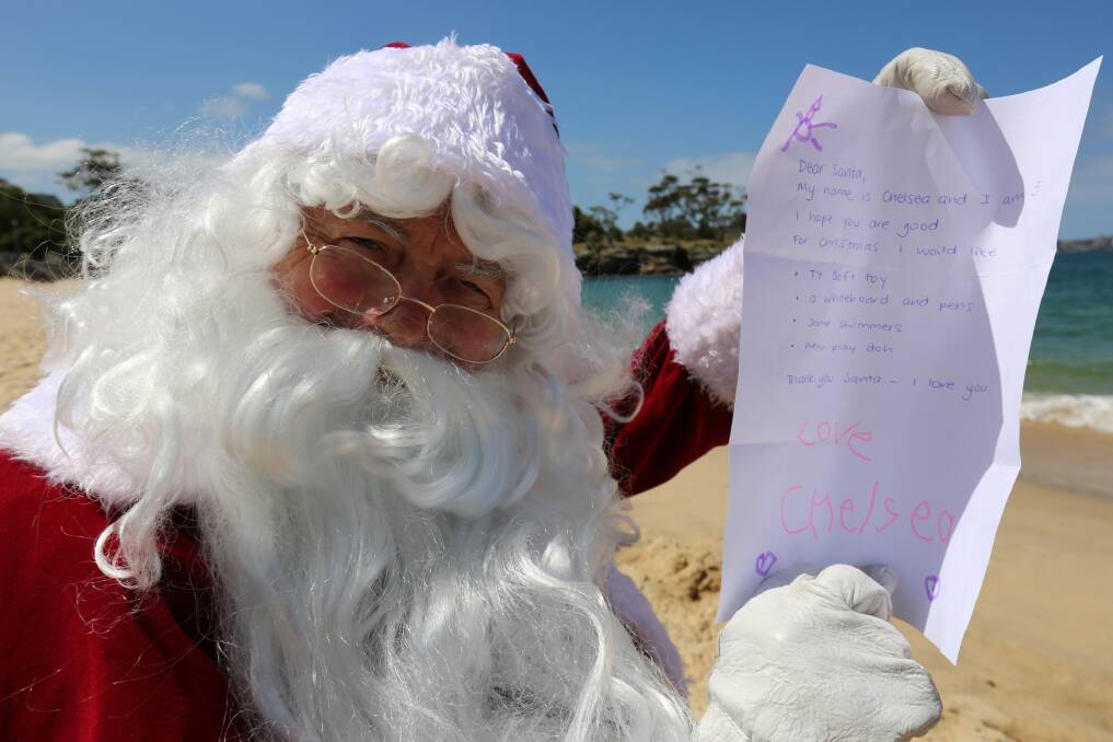 CHRISTMAS WISHES: Santa taking some time out at the beach before his big Christmas run.