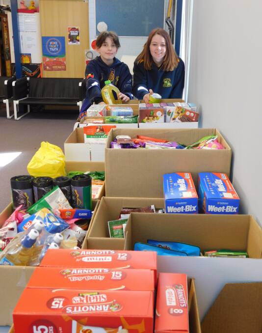 COMMUNITY: Cessnock High School Interact Club members Tracy-Anne Bond and Jade Perry look over the club's food drive donations. Picture: Ryan Rumsey