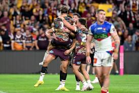 Brendan Piakura is congratulated by his Brisbane teammates after scoring against Newcastle. Picture Getty Images