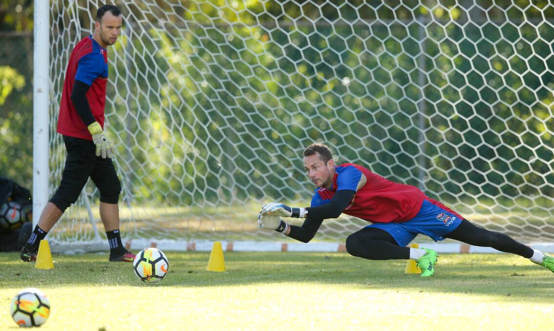 EYES ON THE PRIZE: Glen Moss dives to make a save during a drill at Jets training on Monday. Picture: Max Mason-Hubers
