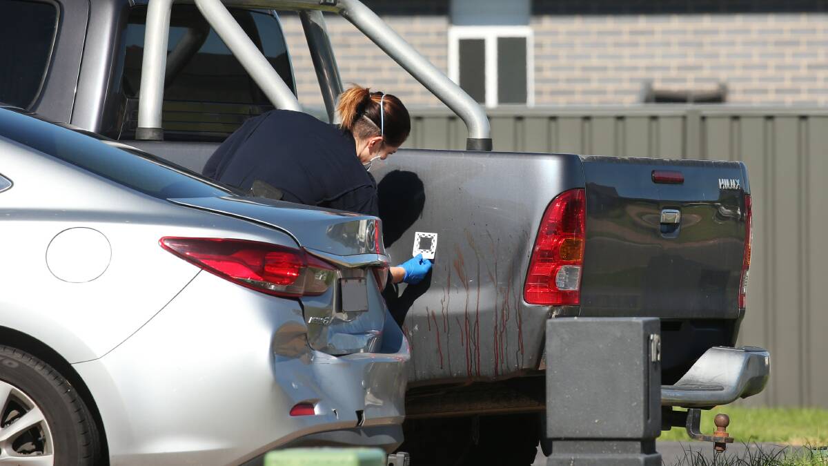 SCENE: Forensic police inspect blood spatter on a vehicle parked in the driveway of the home where the stabbing occurred. Picture: Simone De Peak