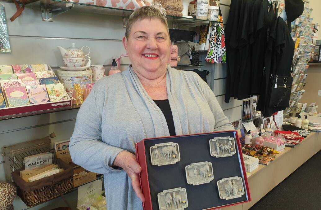 MEMORABILIA: Christine Brown holding the set of five pewter belt buckles featuring pit horses that she has donated towards the project.
