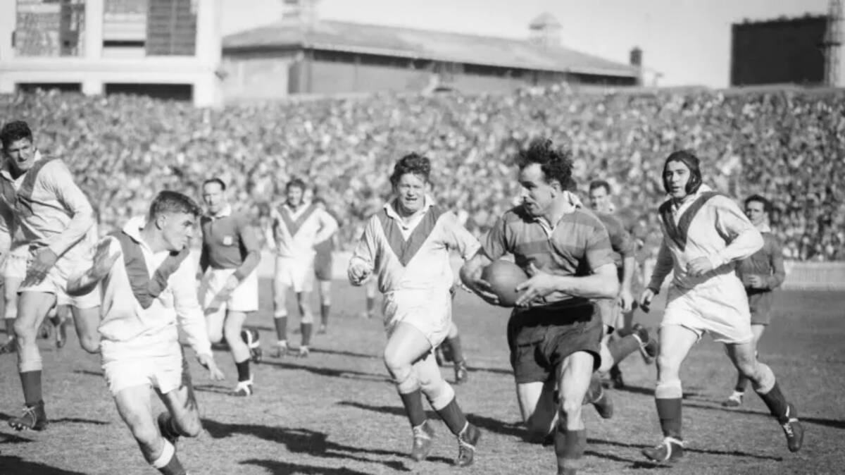 OLD SCHOOL: Clive Churchill weaving his magic for the Rabbitohs against the Dragons at the SCG in 1953. Photo: Harry Martin