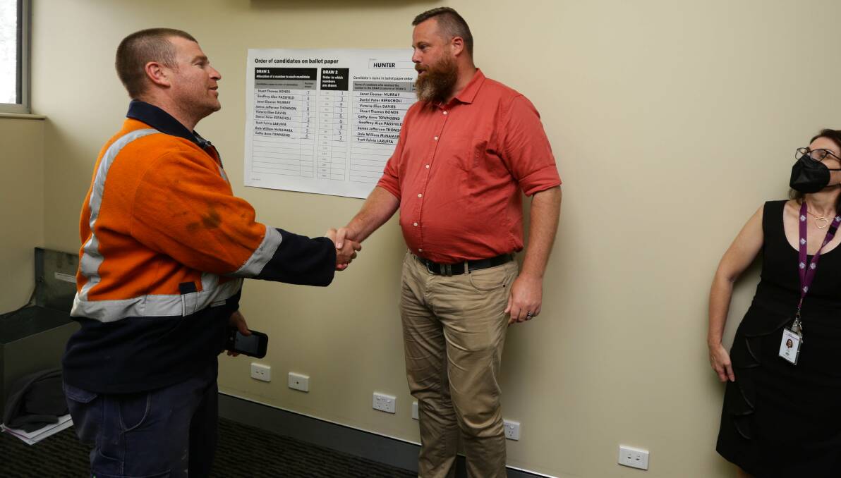 ON YOUR MARK: Independent Stuart Bonds and Labor's Dan Repacholi shake hands after the Hunter ballot draw at East Maitland Library on Friday. Picture: Jonathan Carroll
