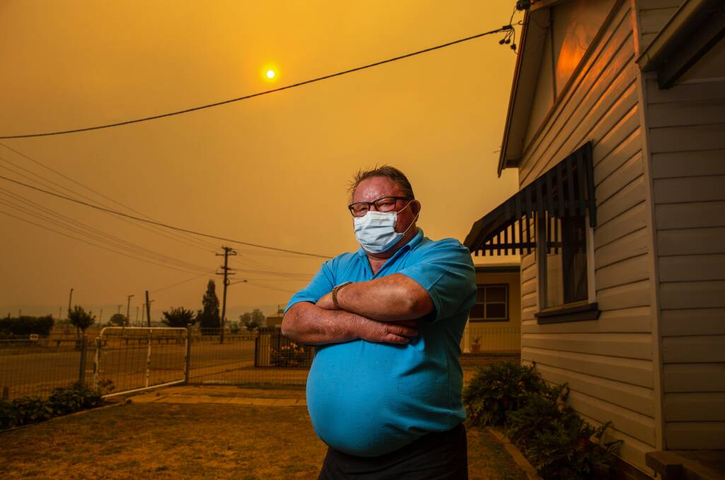 SMOKE HAZE: Brian White, 70, outside his home in Cessnock in December. He has emphysema, and wore a face mask during the bushfires near Wollombi as a protective measure. Picture: Marina Neil 