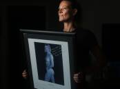Tracie McGovern with her framed print from the Matildas calendar in 1999. Picture by Simone De Peak
