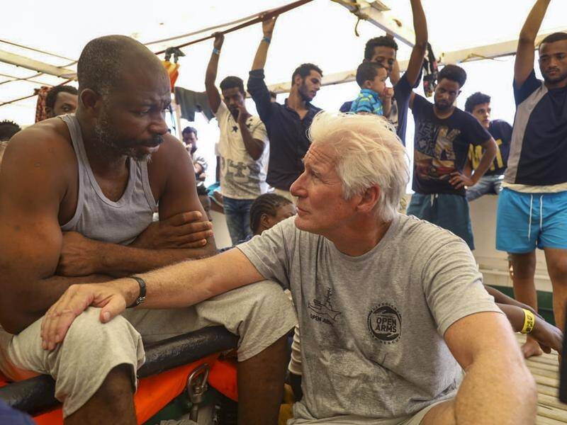 Actor Richard Gere has taken food to 121 migrants stuck on board a rescue ship in the Mediterranean.