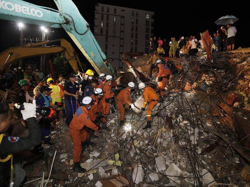 Rescuers search for missing workers in the rubble of a collapsed building in Cambodia.