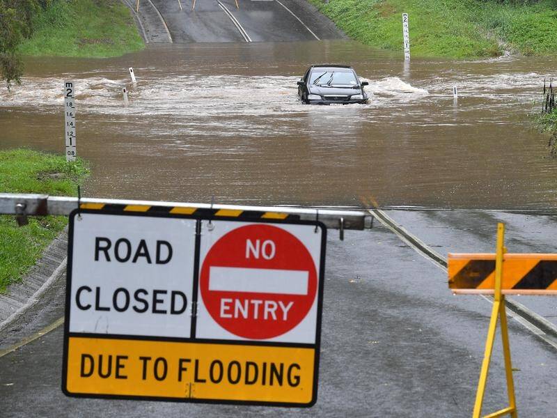 Heavy rain has triggered a landslide and caused school and road closures in north Queensland.
